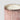 Close-up of a pink fluted mercury candle jar with metallic rose-gold speckles, a white wax fill, and a silver-toned rim on a light gray background.
