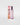 A Petra Living 'Mon Amour' travel spray perfume bottle with a metallic pink cap stands next to its pink packaging box on a light gray background.