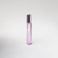 Pink bottle of perfume on white background.