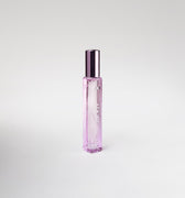 Pink bottle of perfume on white background.