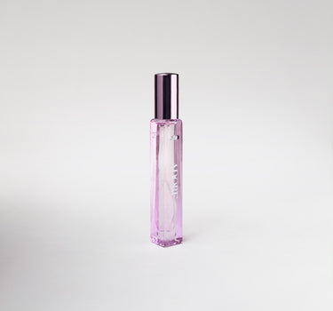 Pink bottle of perfume on white background.