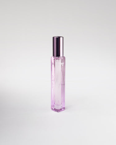 Pink perfume bottle with a metallic cap on a light gray background