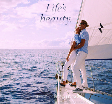 Couple embracing on a sailboat with 'Life's Beauty' text and product placement.