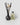 A reed diffuser with a dark smoky glass bottle, black reeds, and three dried white lotus flowers, with a 6oz refill of the ADORE MON AMOUR fragrance by PETRA LIVING, photographed on a light gray background.