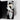 A gift box presentation featuring dried white flowers wrapped in light gray tissue paper and tied with a satin ribbon, set inside an open black gift box on a light gray background.