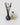 A reed diffuser with a dark smoky glass bottle, black reeds, and three dried white lotus flowers, with a 6oz refill of the ADORE TRACKSIDE SOLEIL DEL MAR fragrance by PETRA LIVING, photographed on a light gray background.