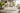 Four candles on a marble surface with a living room background summer hamptons home