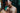 Two people embracing with a blurred natural background