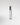Clear glass 'Leather Noir' perfume bottle with silver cap on a light gray background