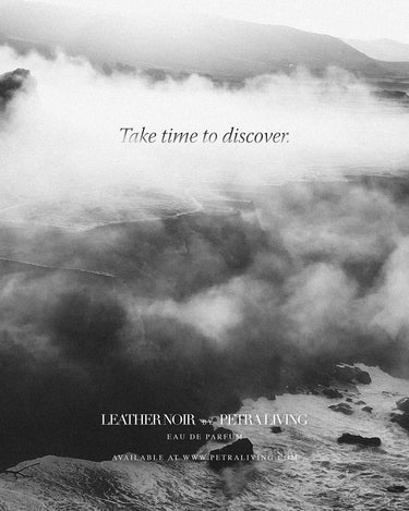 Black and white image of a mountain landscape with clouds and a quote about taking time to discover, with Petra Living branding.