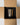 A cylindrical glass candle with a marbled gray, black, and beige pattern, packaged inside a black foam insert within an open brown cardboard box.