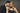 Man and woman posing closely against a gray background