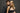 Man and woman posing closely against a dark background