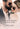 A close-up lifestyle photo of a man and woman wearing aviator sunglasses, with overlaid text reading 'This is the art of fragrance as necessary couture.' and the brand name 'PETRA LIVING' at the bottom.