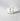 Clear candle in a glass container with a label on a light gray background petite bougie votive