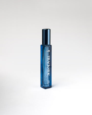 Blue perfume bottle with 'Trackside' branding on a white background