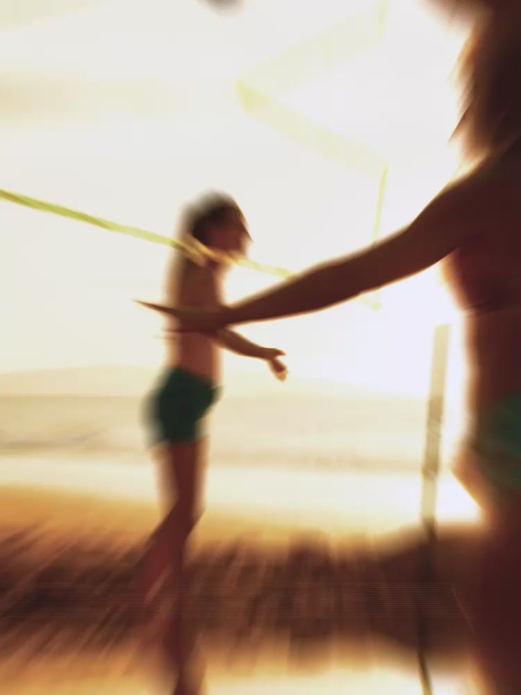 Surfing and friends playing volleyball on the beach