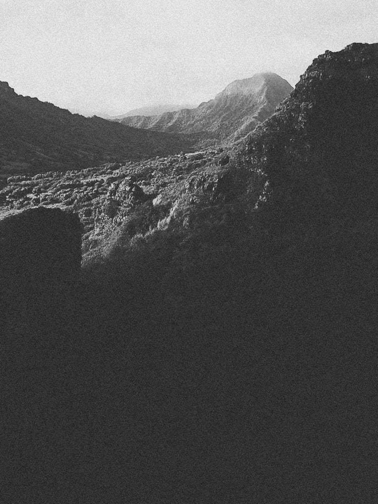 Two people riding a motorcycle on a winding road with a scenic landscape.